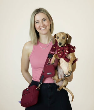a dog mom wearing the fur ever love bag and holding her dog matching 