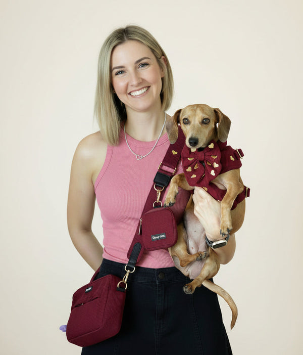 a dog mom wearing the fur ever love bag and holding her dog matching 