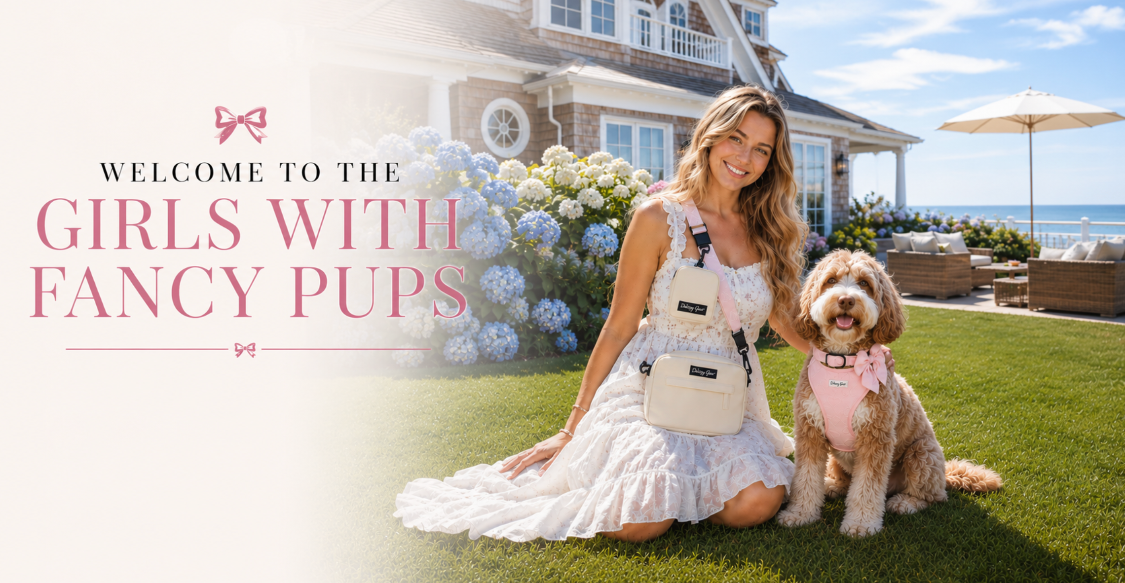 Woman in a white dress with a dog in a pink outfit in front of a house with flowers and ocean view.