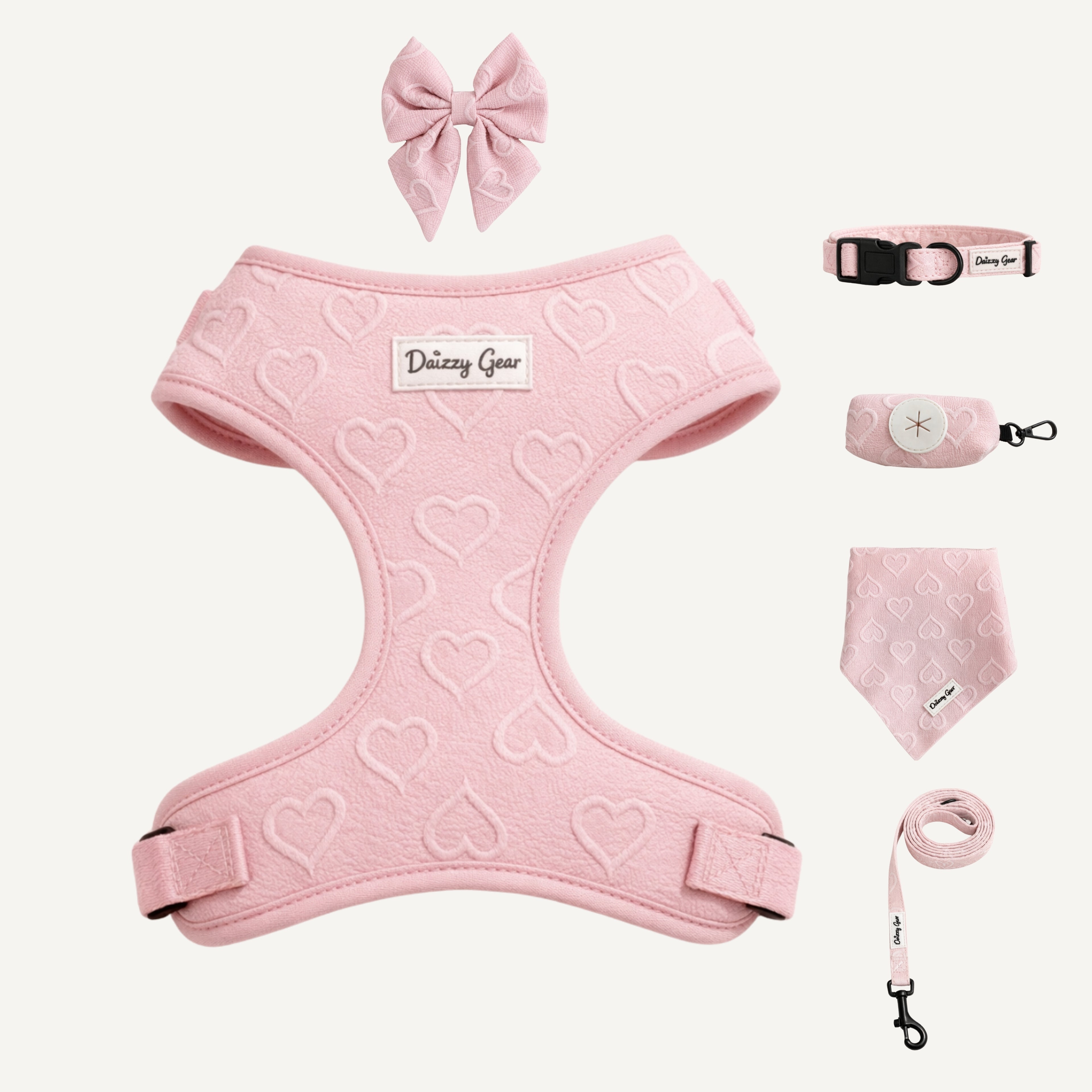 Pink pet harness with heart patterns, matching collar, leash, and bandana on a white background.