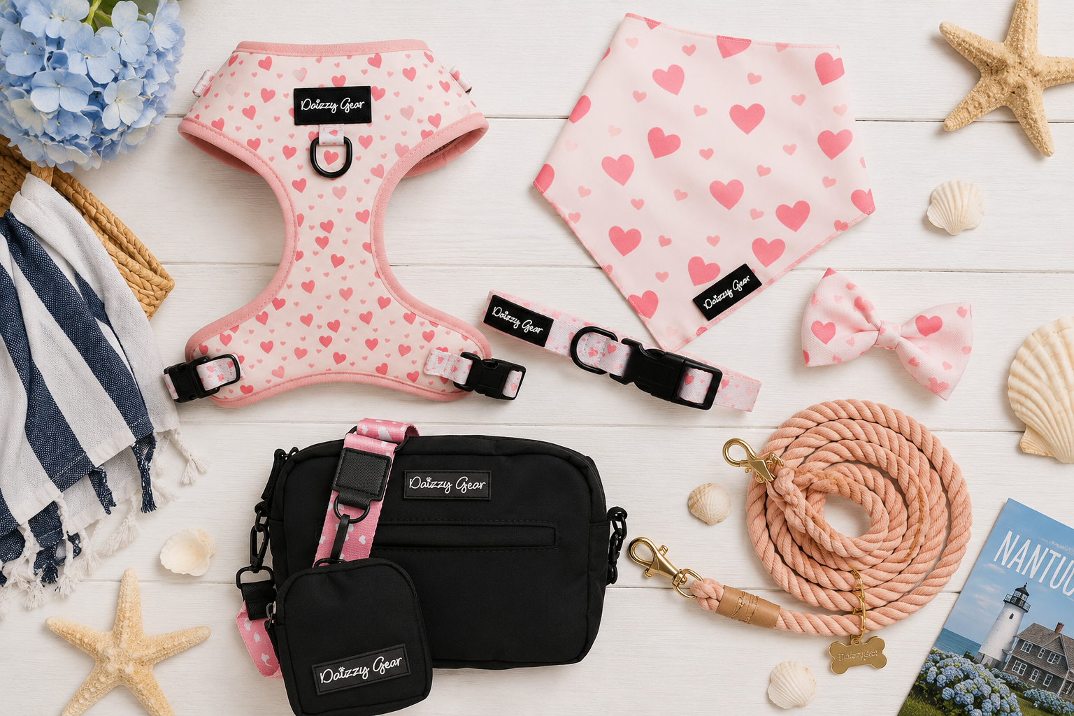 Dog accessories including a pink harness, bandana, collar, leash, and bag on a wooden surface with decorative items.